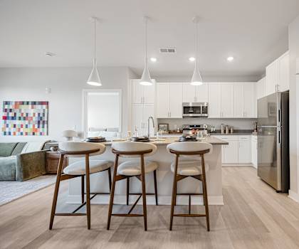 A kitchen with white cabinets and a white fridge.